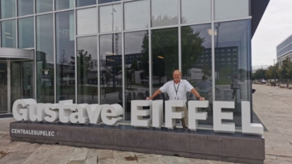 Photo of Dr. Davit Coit standing behind sign of Gustave Eiffel