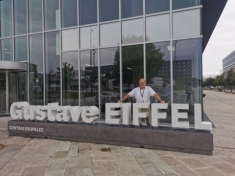 Photo of Dr. Davit Coit standing behind sign of Gustave Eiffel