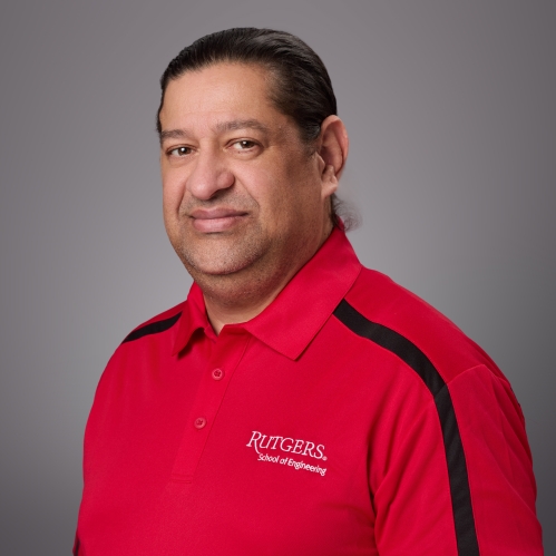 Headshot of male with dark short hair wearing a red Rutgers School of Engineering polo with a black strip going down the sleeve.