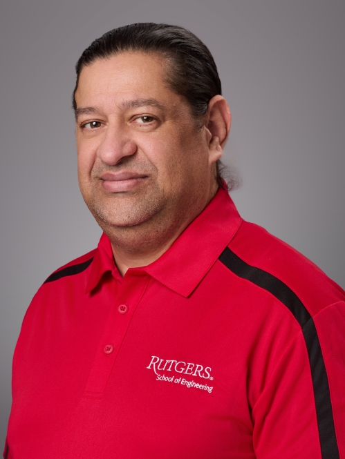 Headshot of male with dark short hair wearing a red Rutgers School of Engineering polo with a black strip going down the sleeve.