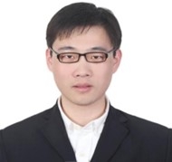 Head shot of Asian male with short black hair, wearing eyeglasses, black suit jacket and a white shirt.